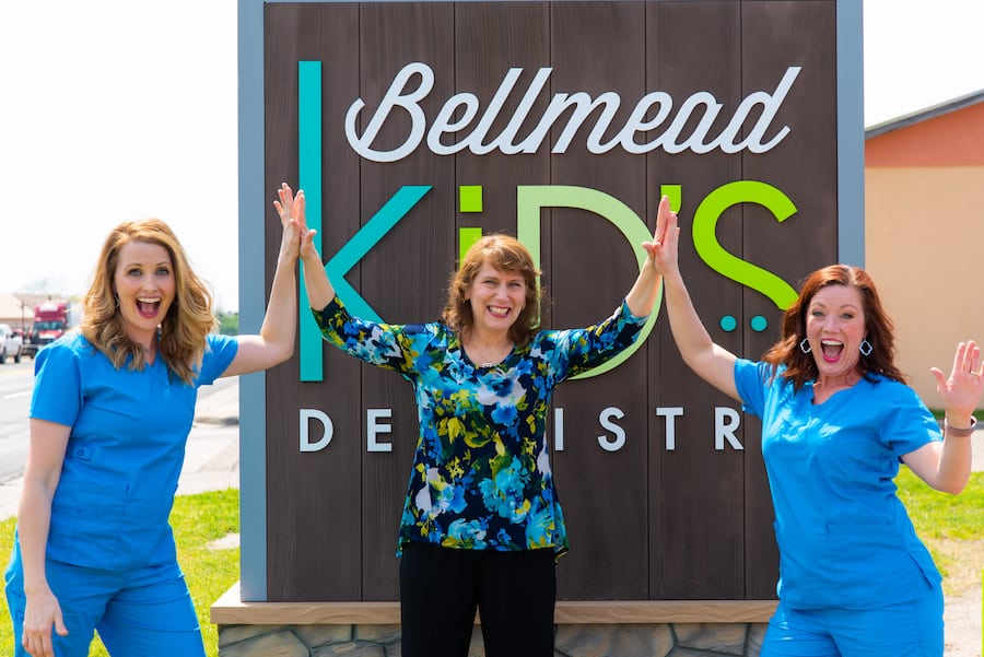 Dr. Francis and two team members in front of bellmead smiles sign